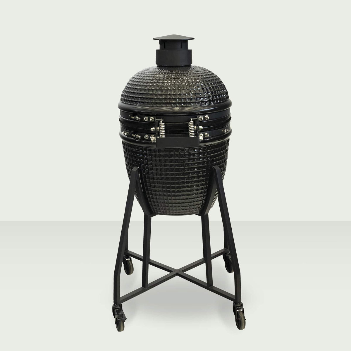 Barbecue Kamado 18" fermé, monté sur un chariot en acier avec roulettes, affichant un design robuste et compact.