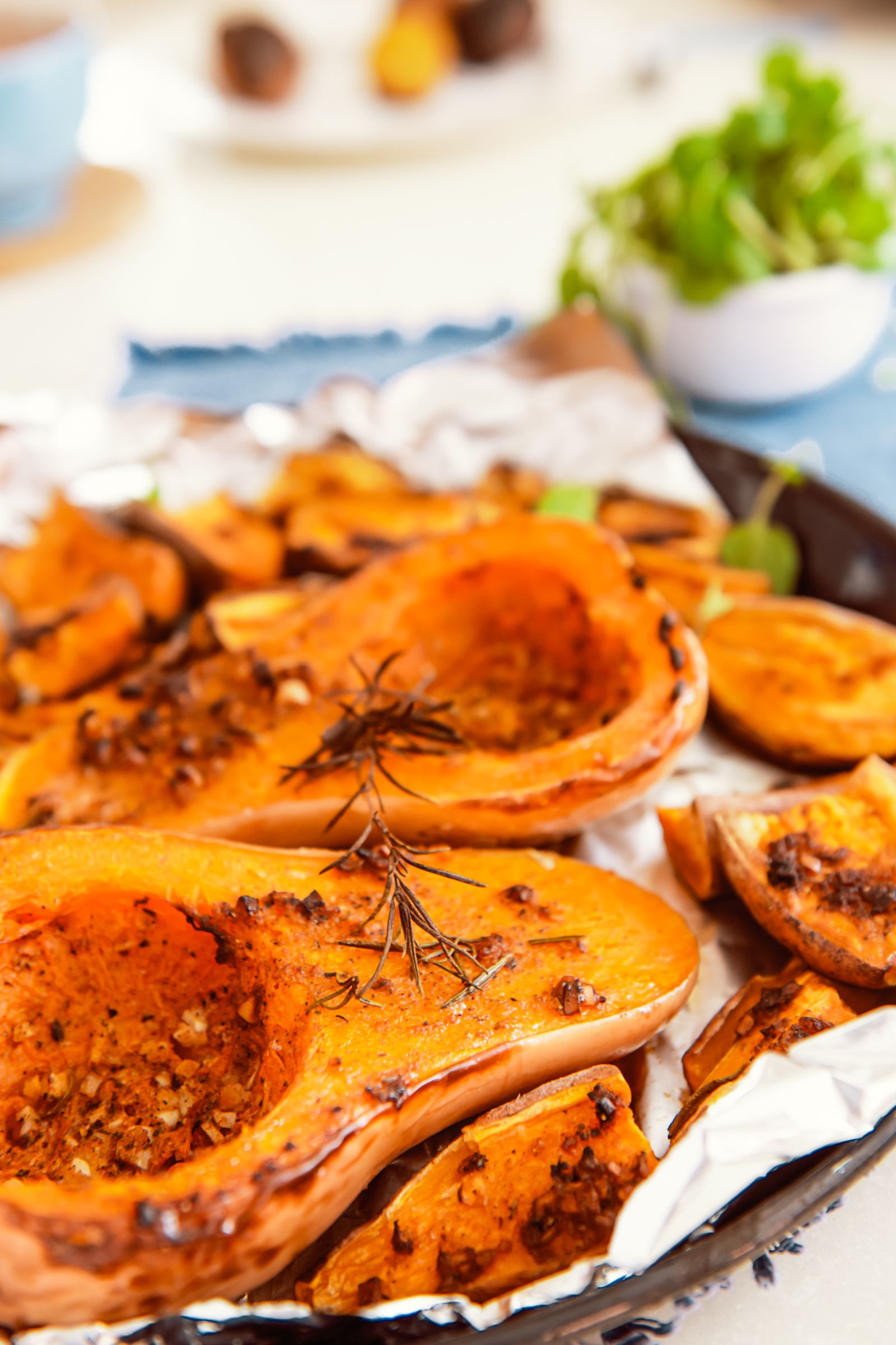 Quartiers de courge butternut rôtis au barbecue kamado, relevés d’ail, de romarin et d’épices.