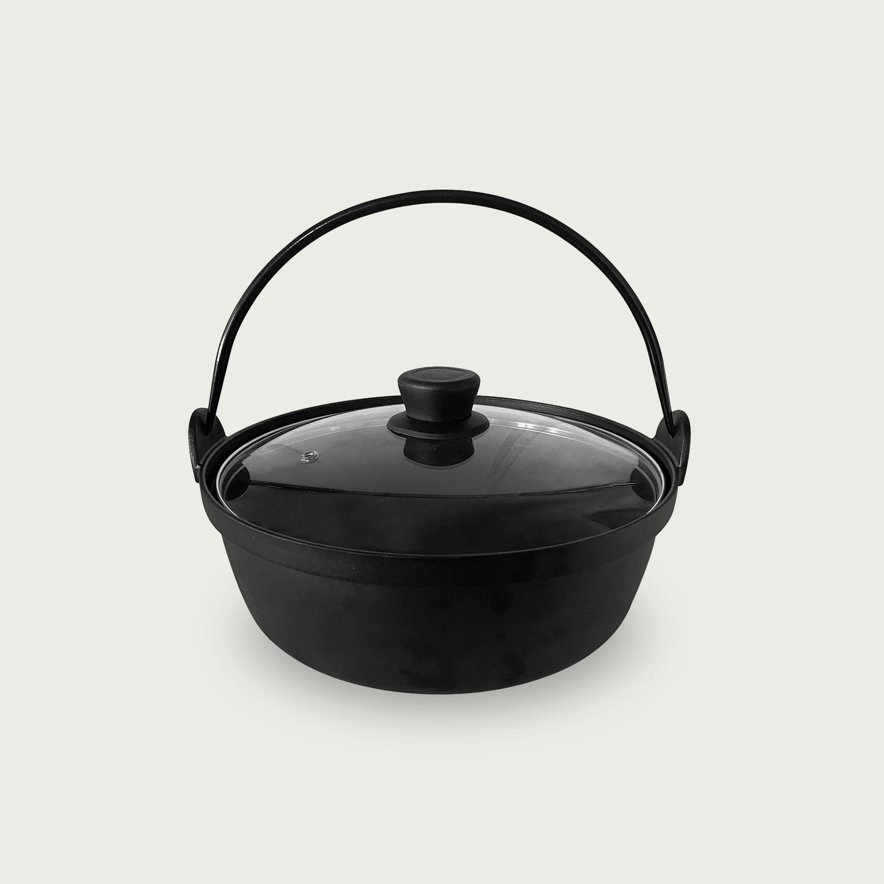 Casserole en fonte noire avec couvercle en verre et anse métallique, conçue pour la cuisson lente et homogène au barbecue kamado.