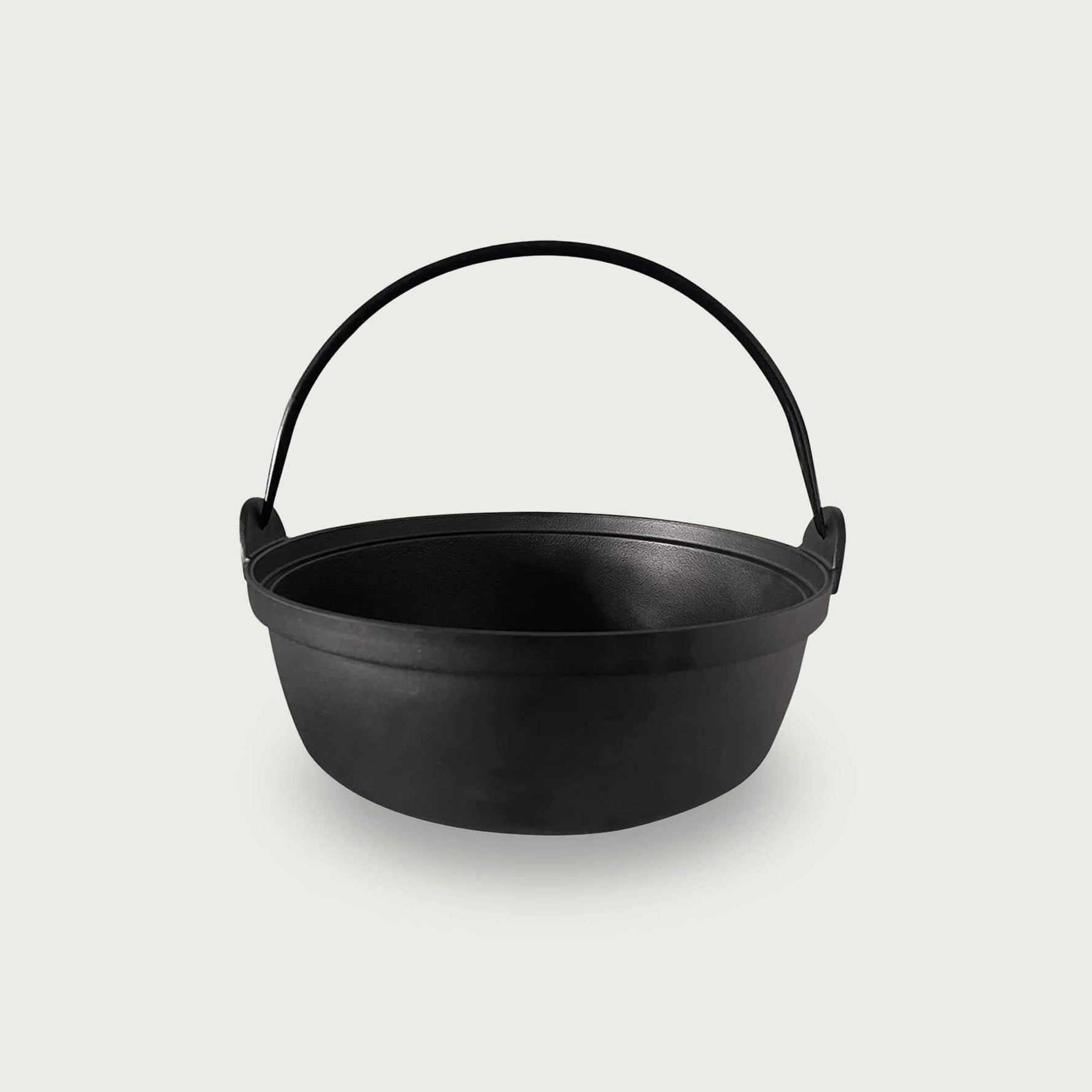Casserole en fonte noire avec anse, idéale pour les cuissons lentes, mijotées ou les préparations directement sur le Kamado.