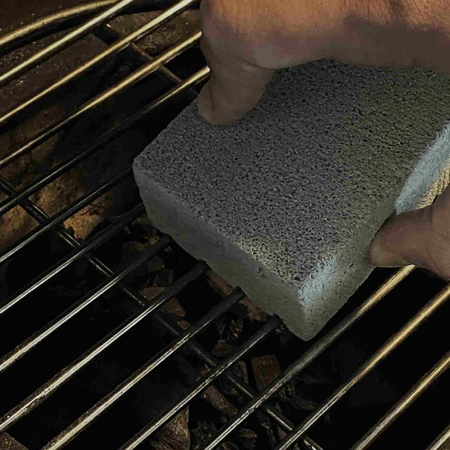 Nettoyage d’une grille de cuisson Kamado à l’aide d’un cube nettoyant en pierre ponce, efficace pour retirer les graisses et résidus incrustés sans rayer l’inox.