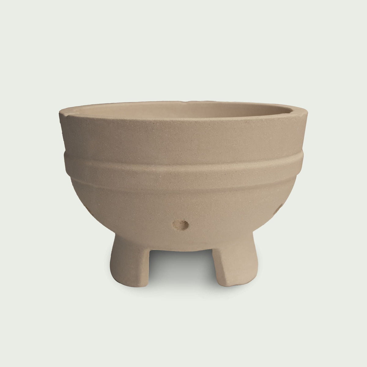 Cuve en céramique beige pour kamado, avec pieds intégrés et orifices d’aération, conçue pour accueillir le foyer et assurer une bonne circulation de l’air.