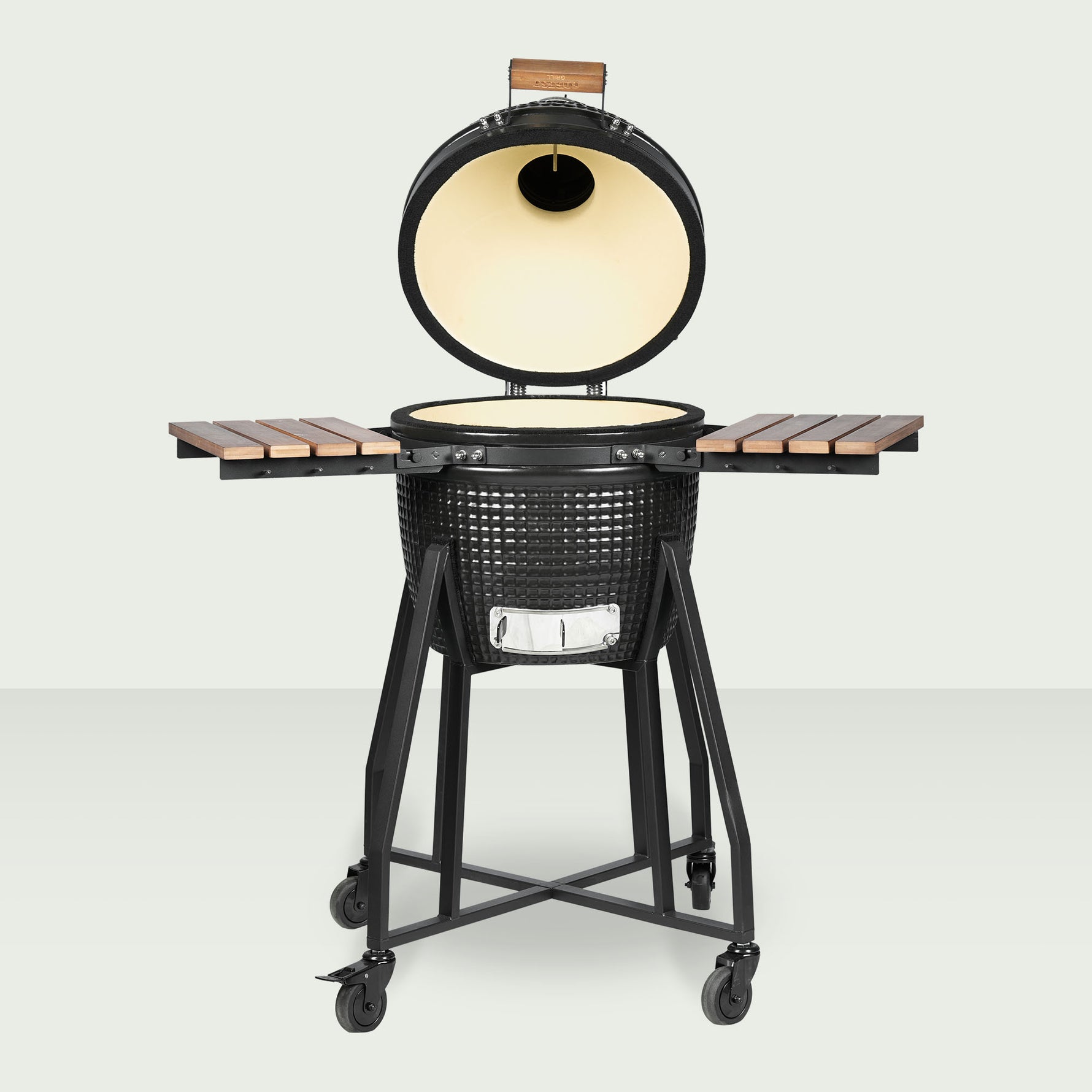 Barbecue Kamado Forestgrill 16" ouvert, avec cuve en céramique noire texturée, intérieur clair, plateaux latéraux en bois et chariot en acier équipé de roulettes.