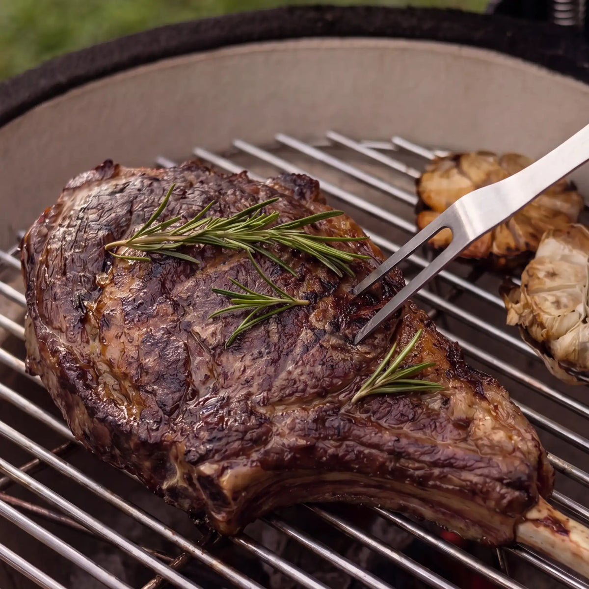 Fourchette de service inox et bois Forest utilisée pour retourner une viande sur le grill