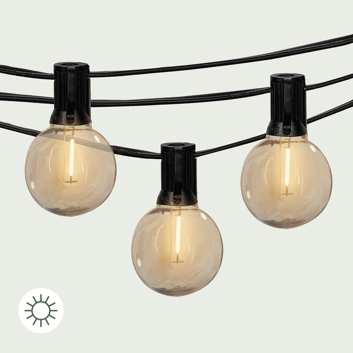 Gros plan sur la guirlande solaire Goya Forest Grill, présentant trois ampoules LED rondes à lumière blanche chaude suspendues sur un câble noir. 