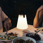 Lampe Cône Forest Grill éclairant une table dressée pour un dîner en extérieur, créant une atmosphère chaleureuse et intime grâce à sa lumière douce et diffuse.