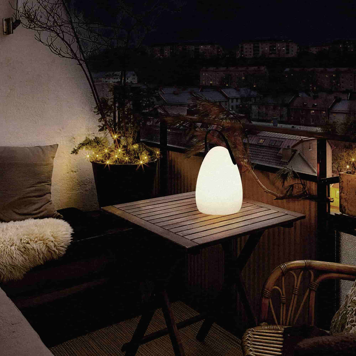 Lampe d’extérieur Œuf Forest Grill posée sur une table de balcon, diffusant une lumière chaude et apaisante pour une ambiance cocooning en soirée.