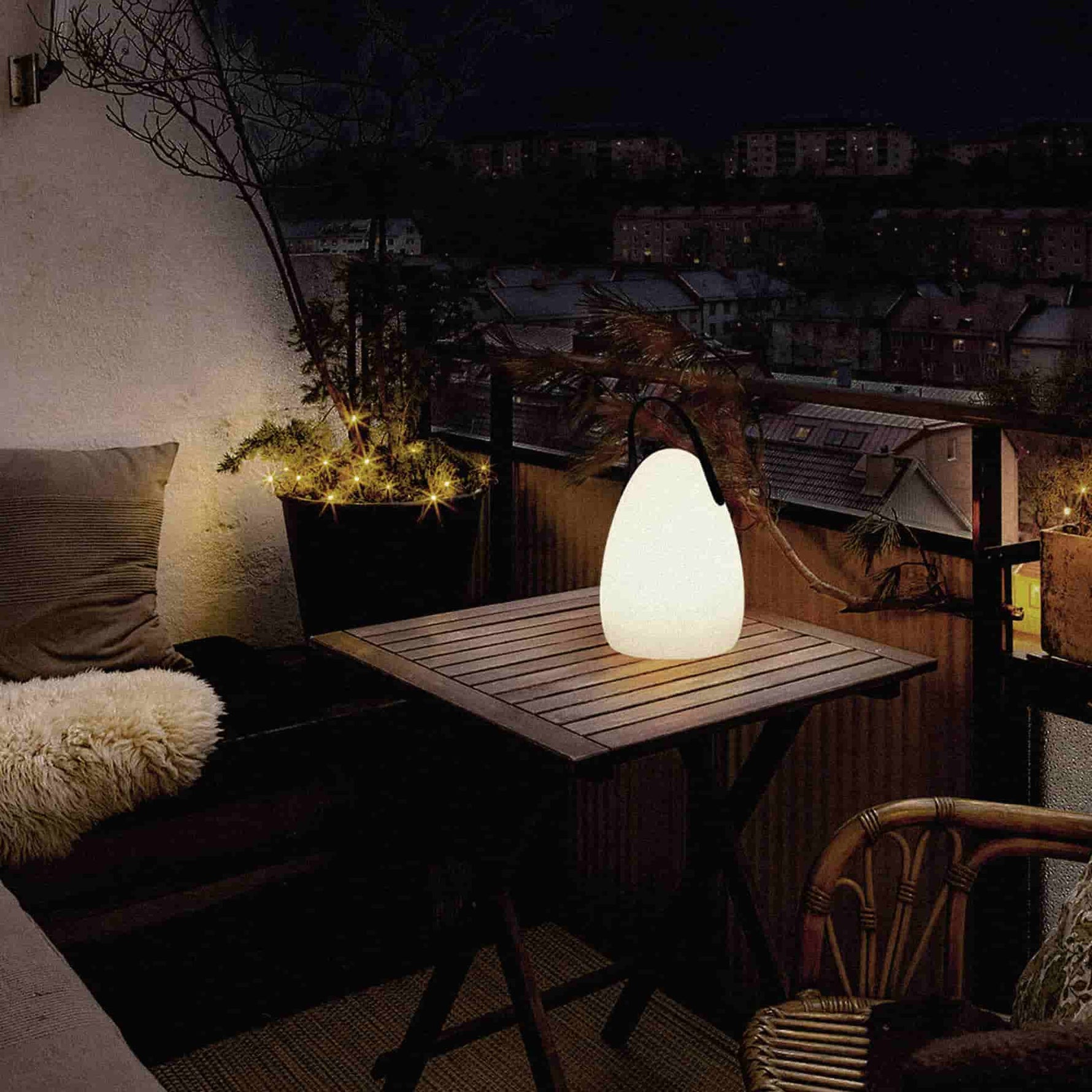 Lampe d’extérieur Œuf Forest Grill posée sur une table de balcon, diffusant une lumière chaude et apaisante pour une ambiance cocooning en soirée.