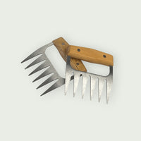 Pair of stainless steel meat claws with wooden handles, used for shredding or handling pieces of meat.