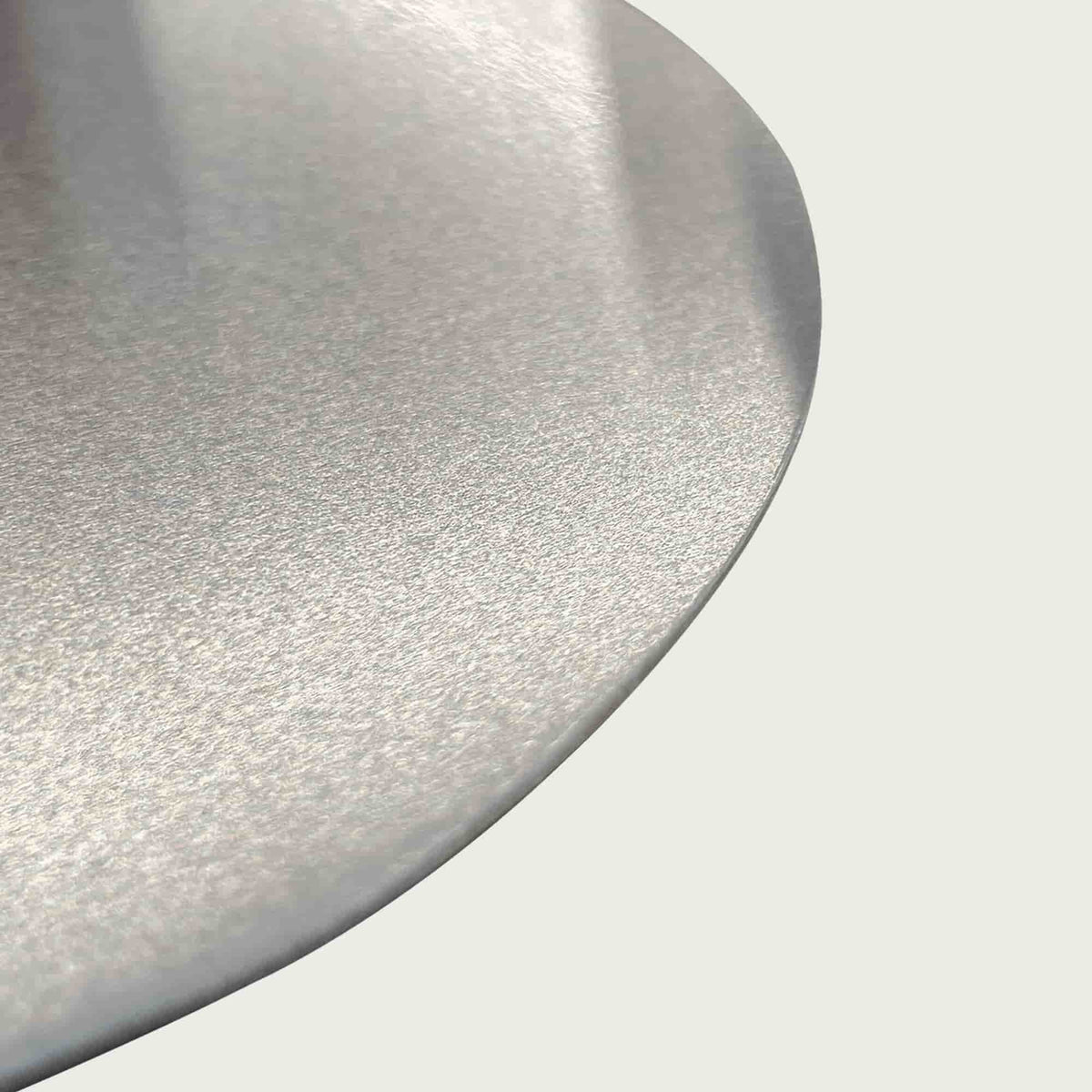 Gros plan sur la surface en inox brossé de la pelle à pizza, soulignant la finition lisse et résistante du métal.