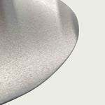 Gros plan sur la surface en inox brossé de la pelle à pizza, soulignant la finition lisse et résistante du métal.