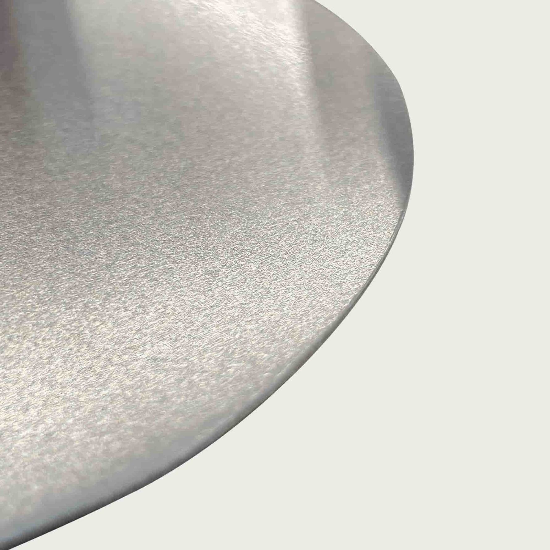 Gros plan sur la surface en inox brossé de la pelle à pizza, soulignant la finition lisse et résistante du métal.