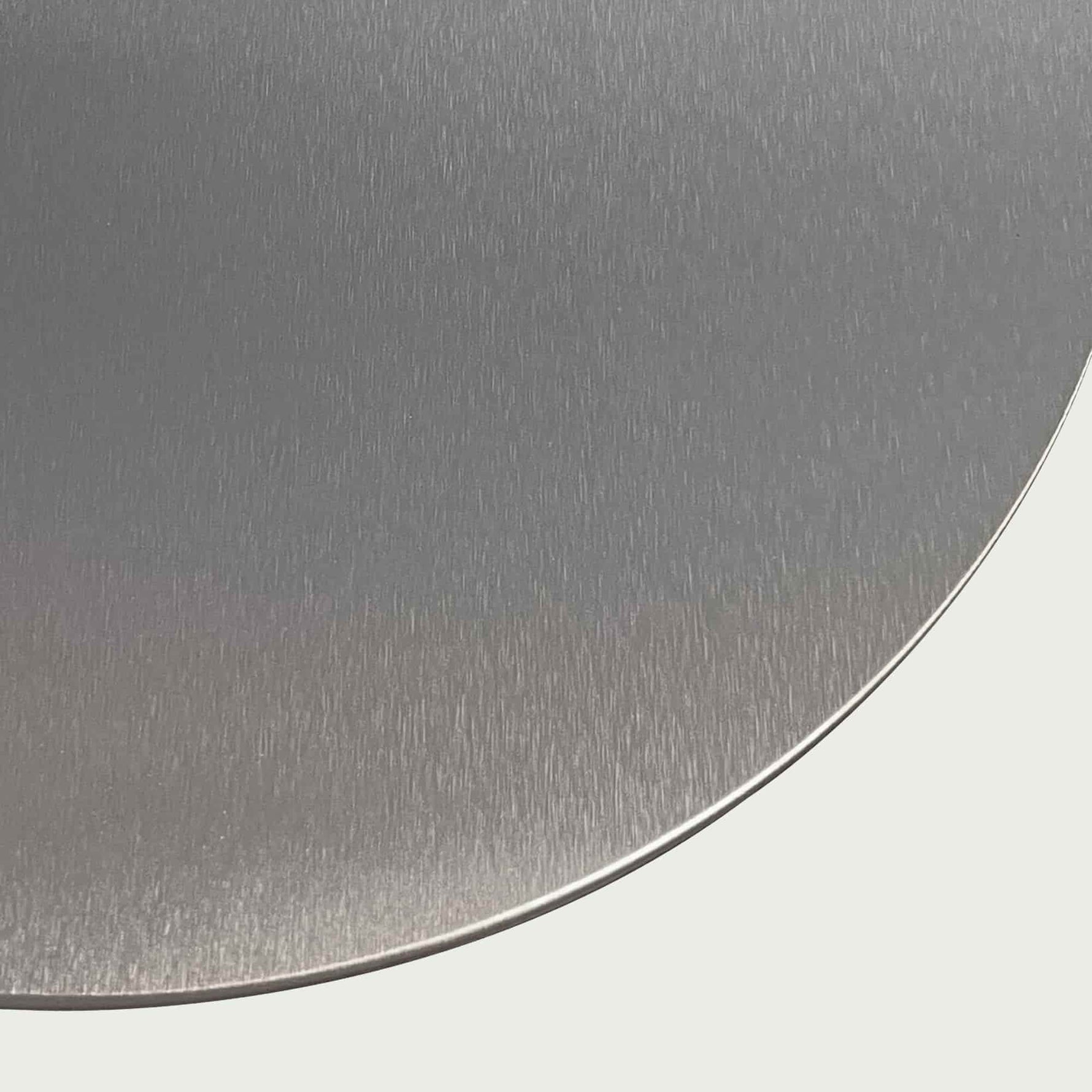 Gros plan sur la surface en inox brossé de la pelle à pizza, soulignant la finition lisse et résistante du métal.