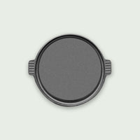 Round cast iron cooking plate, ideal for even heat distribution and preparing meats, vegetables, or crepes on the barbecue.
