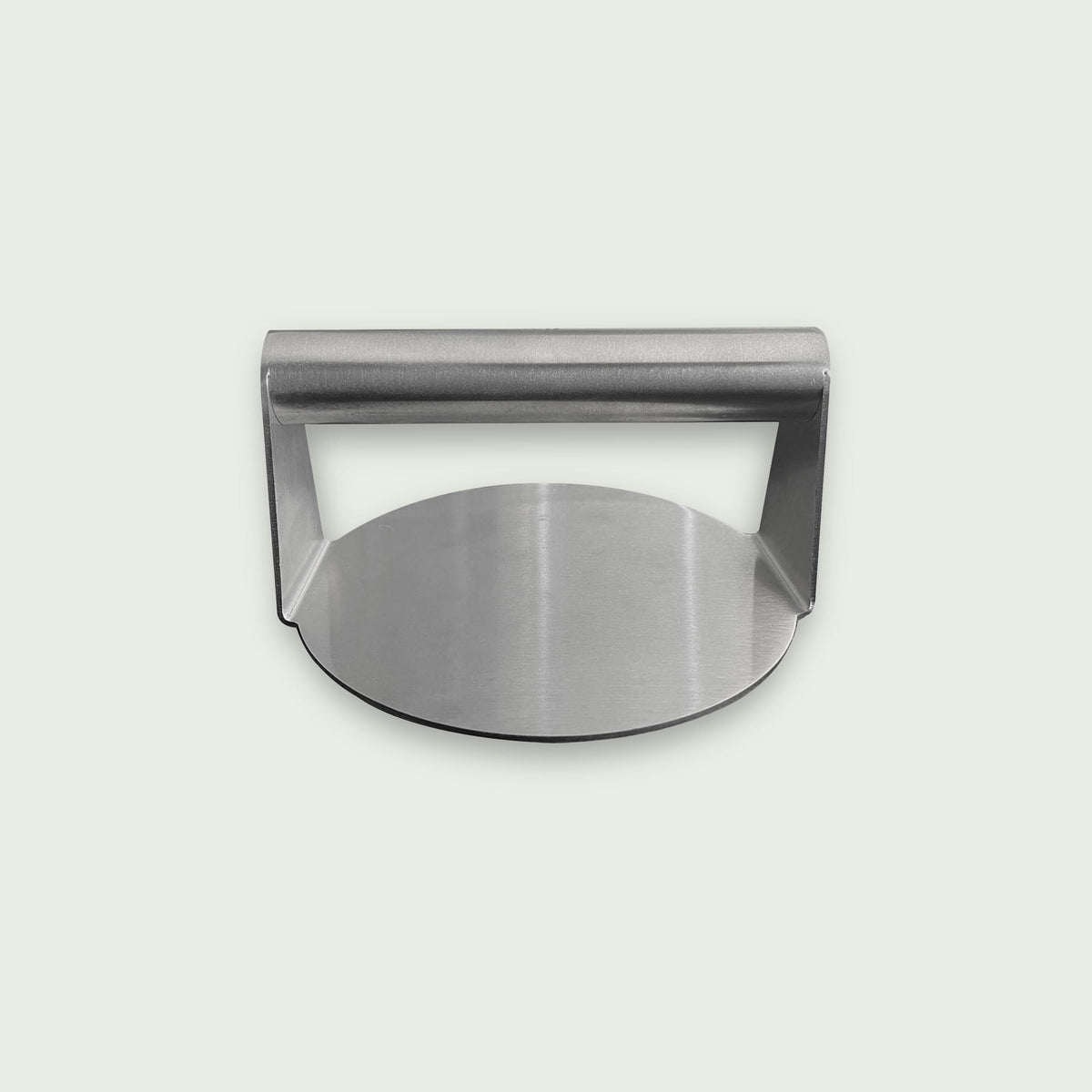 Presse à burger en acier inoxydable avec poignée intégrée, présentée sur fond clair, de face, idéale pour aplatir et cuire uniformément les steaks sur plancha ou barbecue.