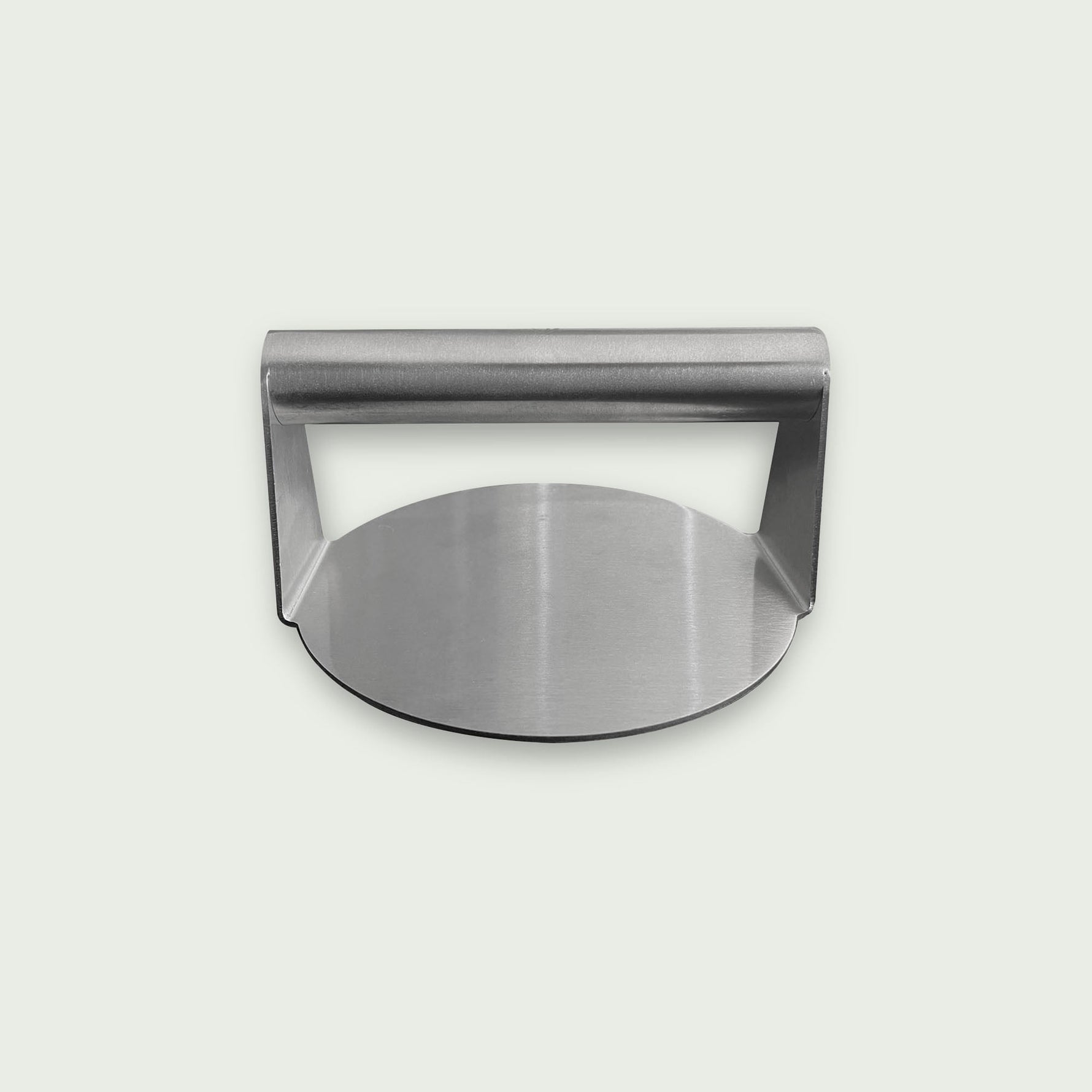 Presse à burger en acier inoxydable avec poignée intégrée, présentée sur fond clair, de face, idéale pour aplatir et cuire uniformément les steaks sur plancha ou barbecue.