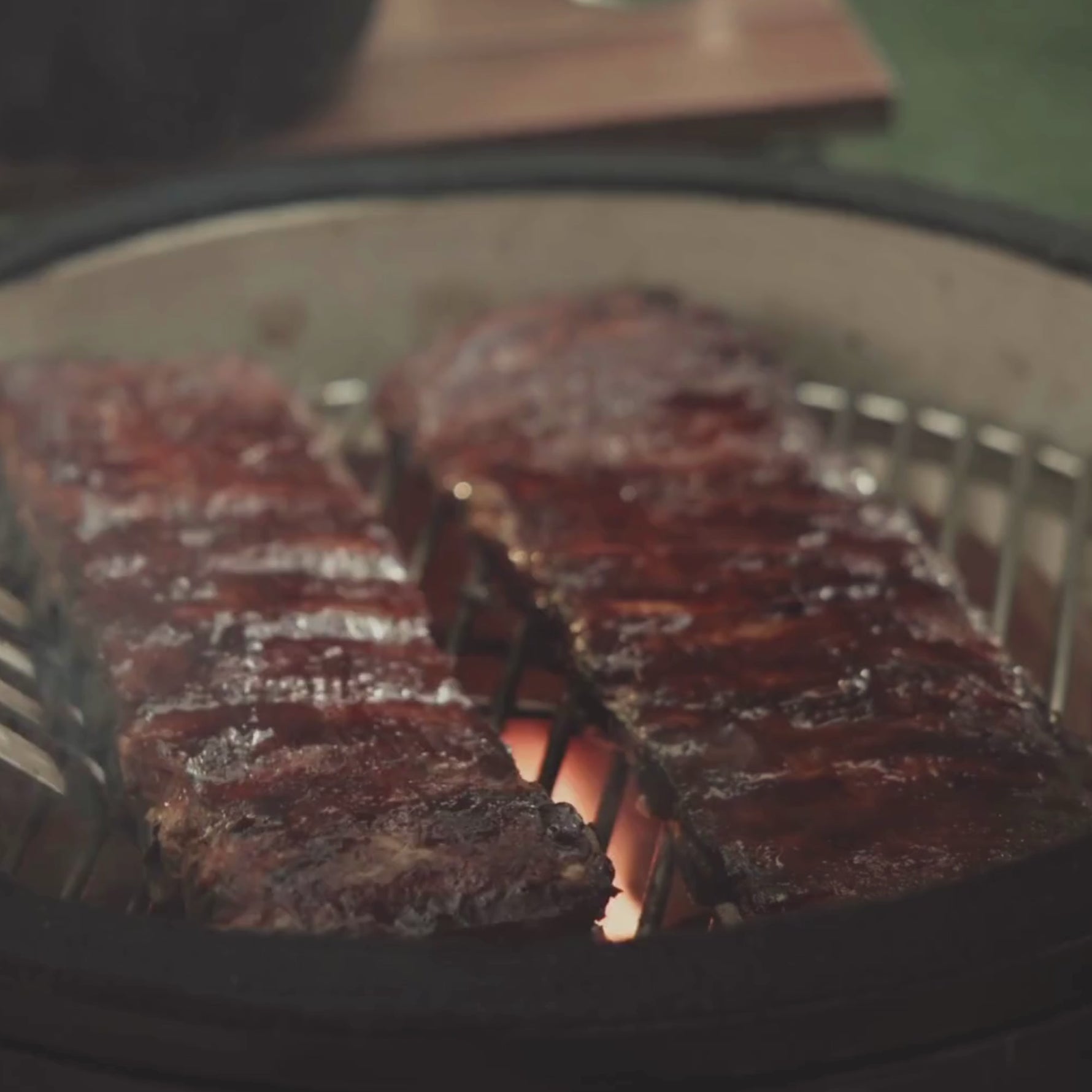 Vidéo présentant le Kamado Forest 16", filmé en rotation pour montrer sa céramique noire texturée, son chariot à roulettes, ses tablettes latérales en bois rabattables et ses détails comme la poignée, les aérations et le thermomètre. La vidéo met en avant le design compact et la qualité de fabrication du modèle 16 pouces.
