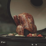 Vidéo présentant un support en fonte pour volaille, placé dans un kamado et montré sous différents angles. On y voit la pièce en fonte robuste utilisée pour cuire une volaille de manière verticale sur le barbecue.