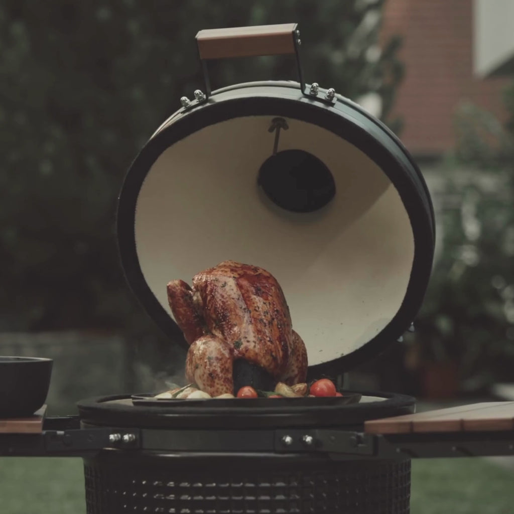 Vidéo montrant un support à poulet en acier inoxydable utilisé sur un barbecue Kamado, illustrant la cuisson verticale d’un poulet pour une répartition homogène de la chaleur.