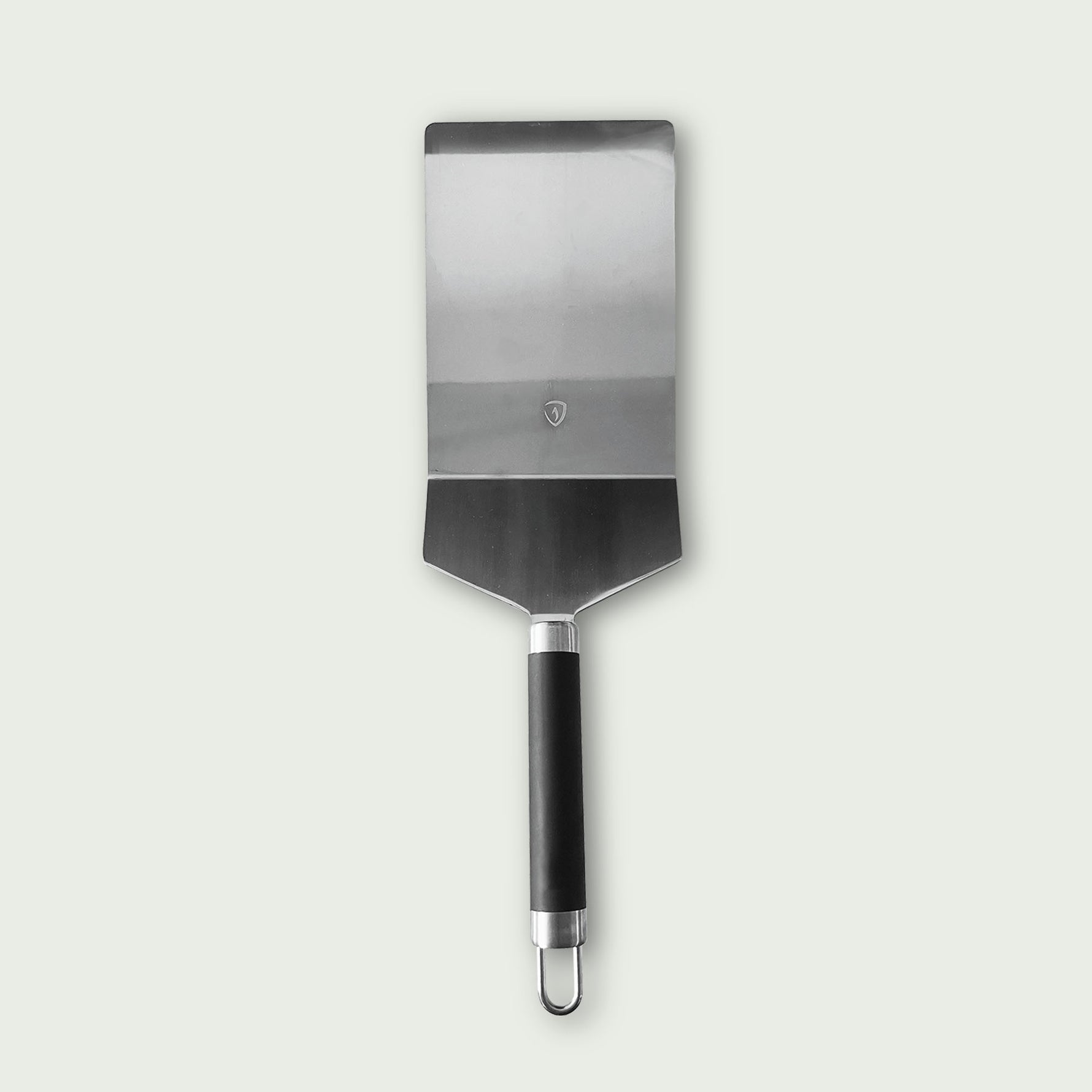 Spatule classique en acier inoxydable avec large lame rectangulaire et manche noir, idéale pour manipuler les aliments sur la plancha ou le barbecue.
