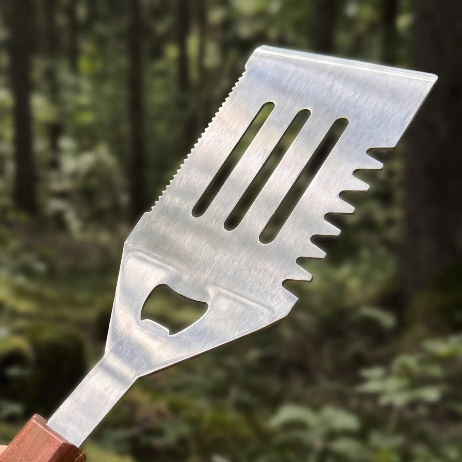 Gros plan sur la lame dentelée et le décapsuleur de la spatule Forest Grill